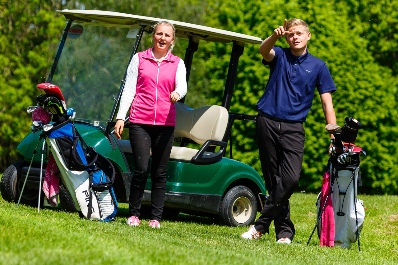 Golf students standing in front of golf cart